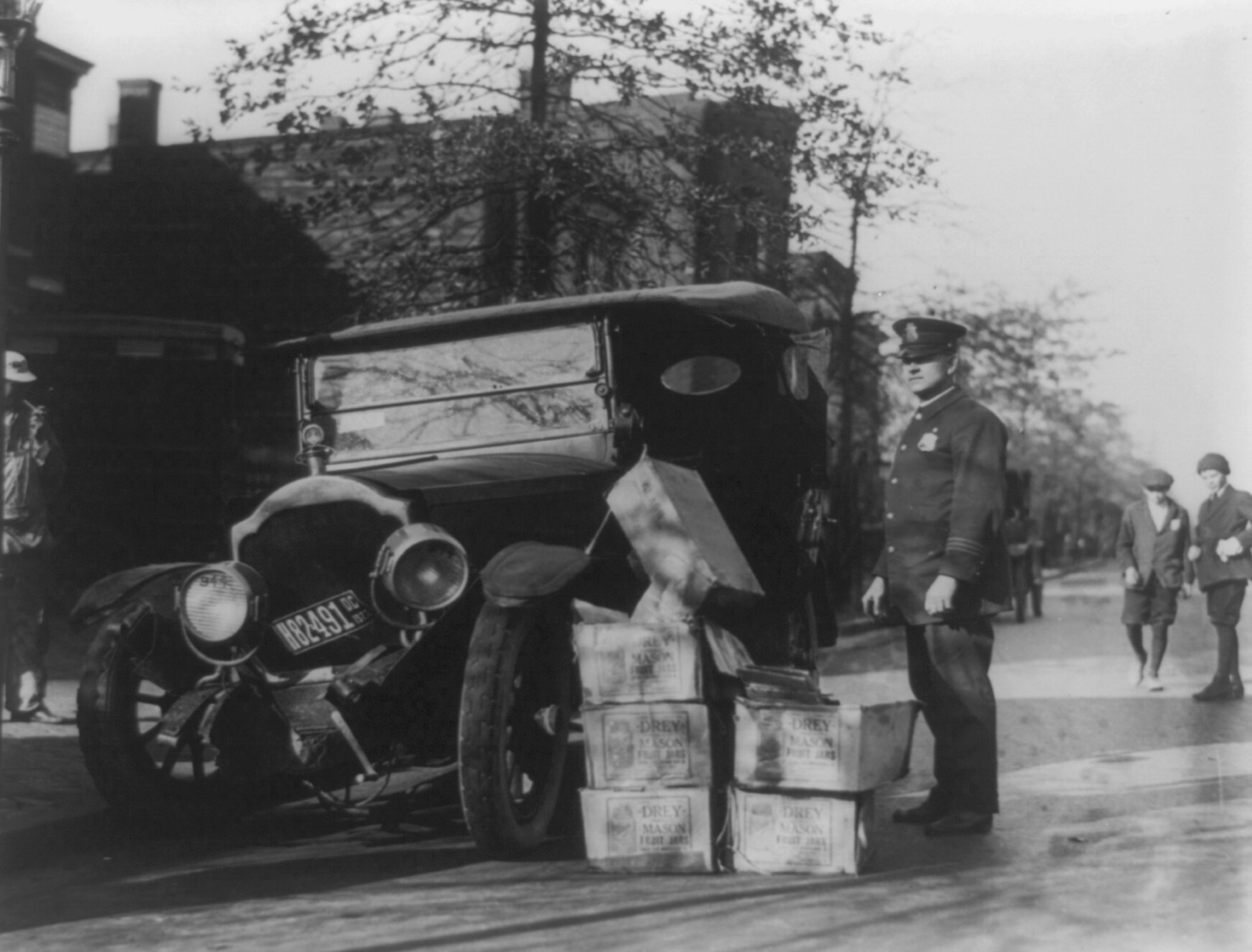 A policeman with wrecked automobile and confiscated moonshine 